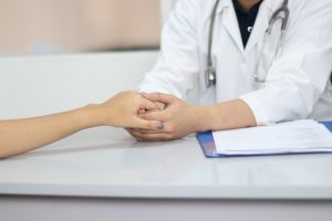 Person holding hands with healthcare provider