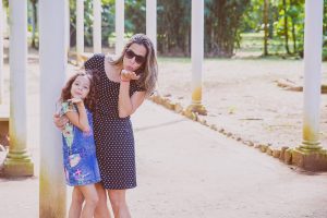 Woman and daughter blowing kisses outdoors