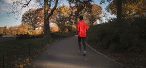 man running on trail through woods